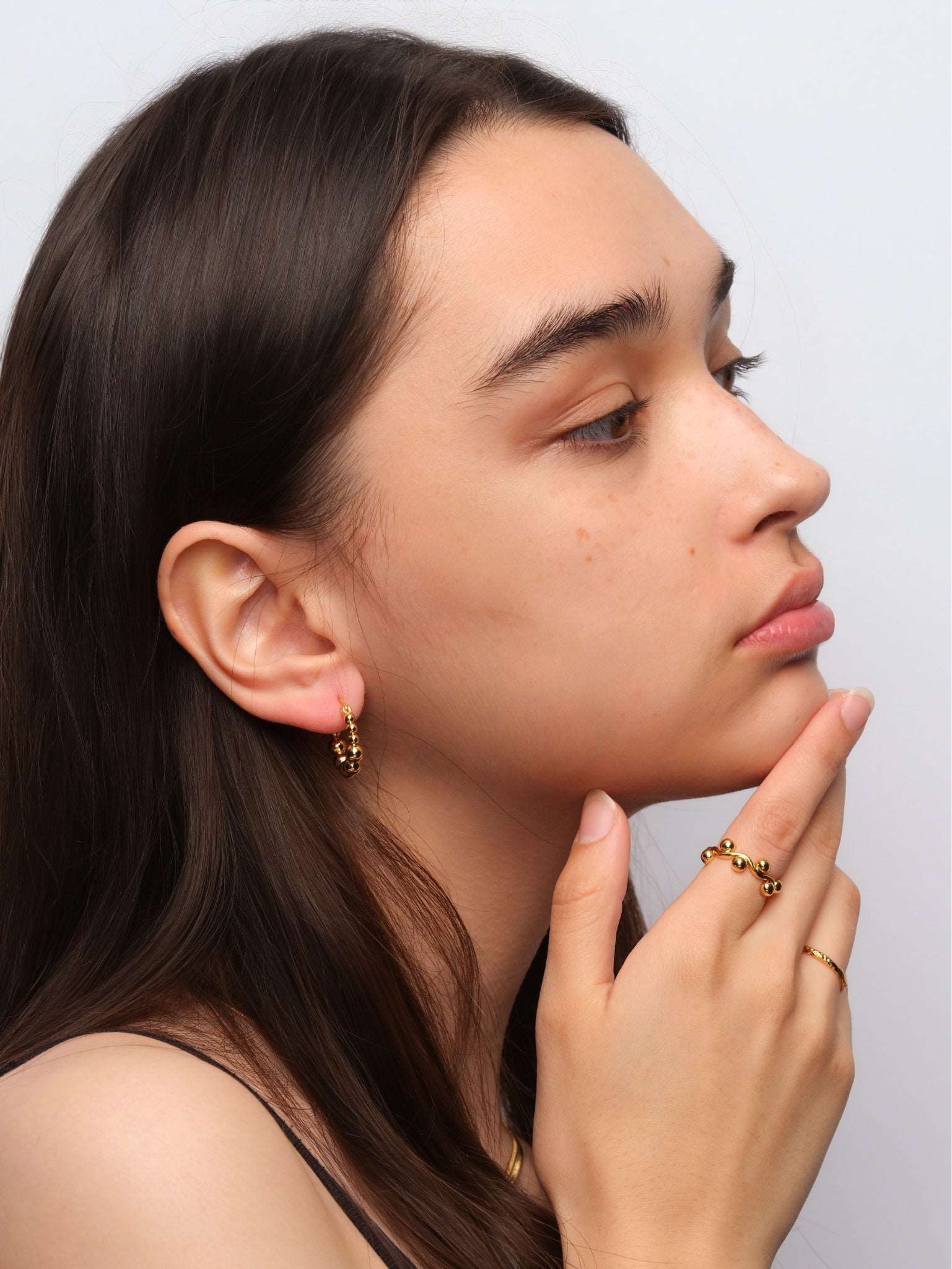 wearing Emery Gold Hoops and mini structure ring