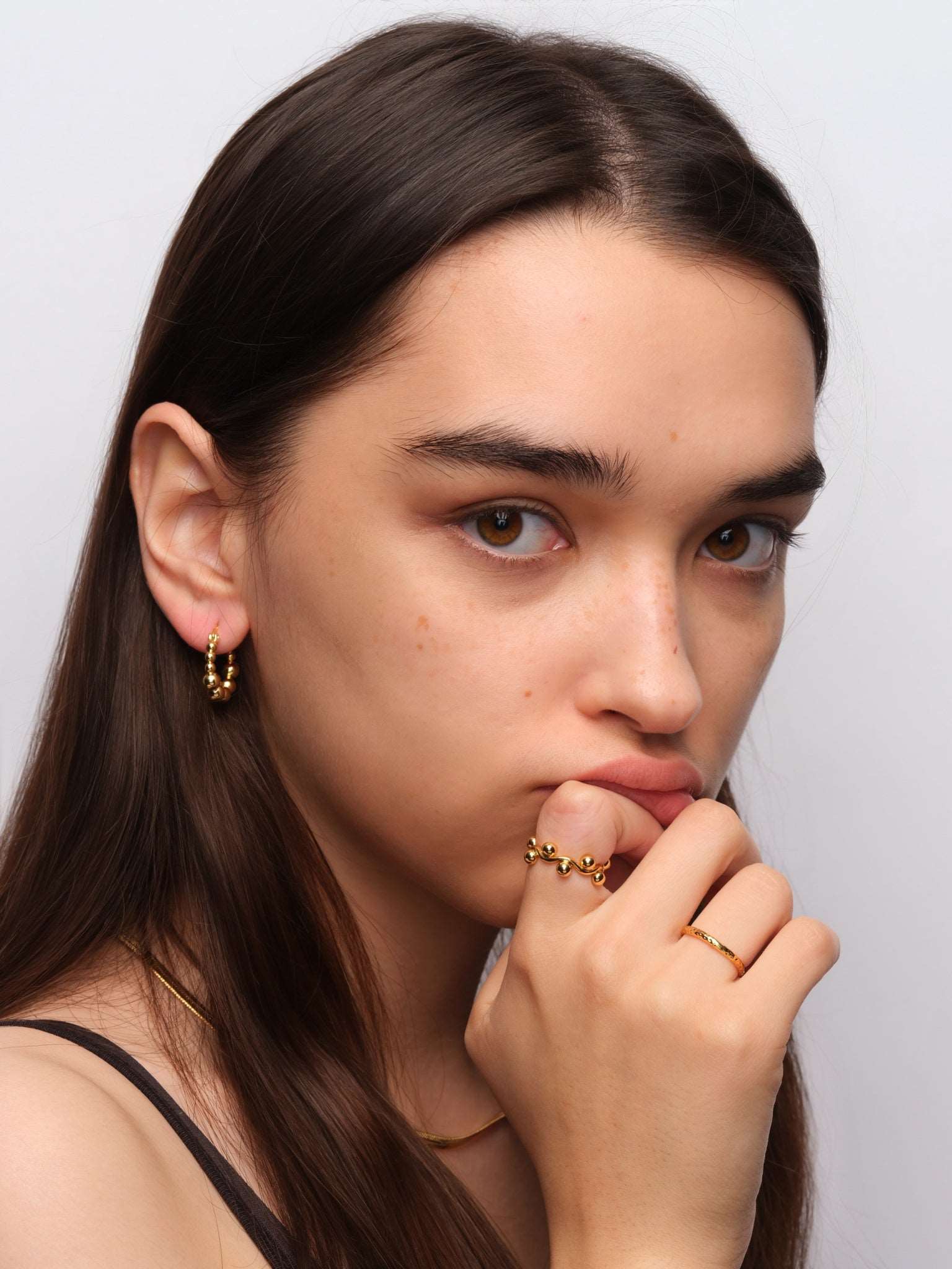 wearing Emery Gold Hoops and mini structure ring