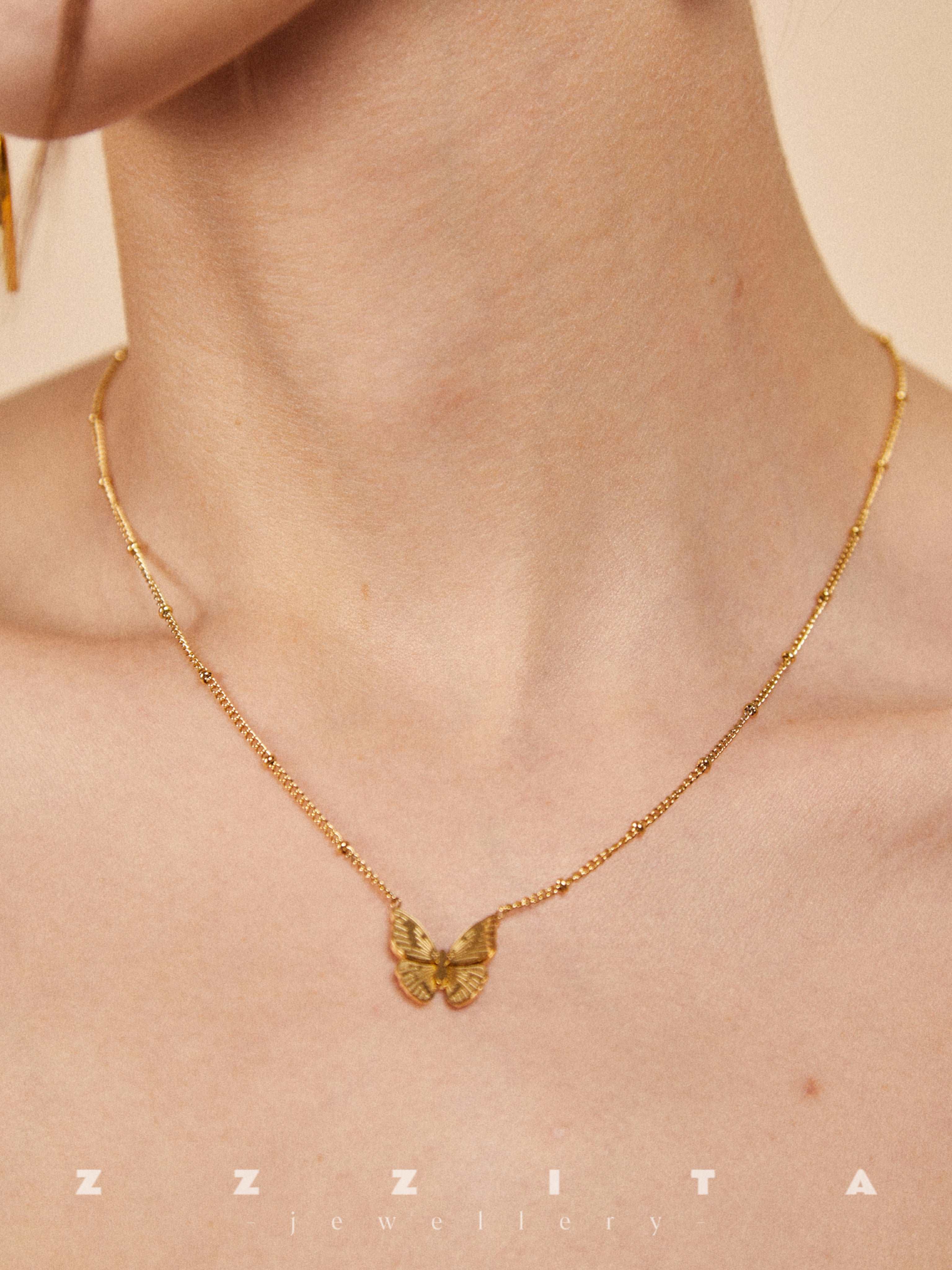 wearing gold butterfly necklace