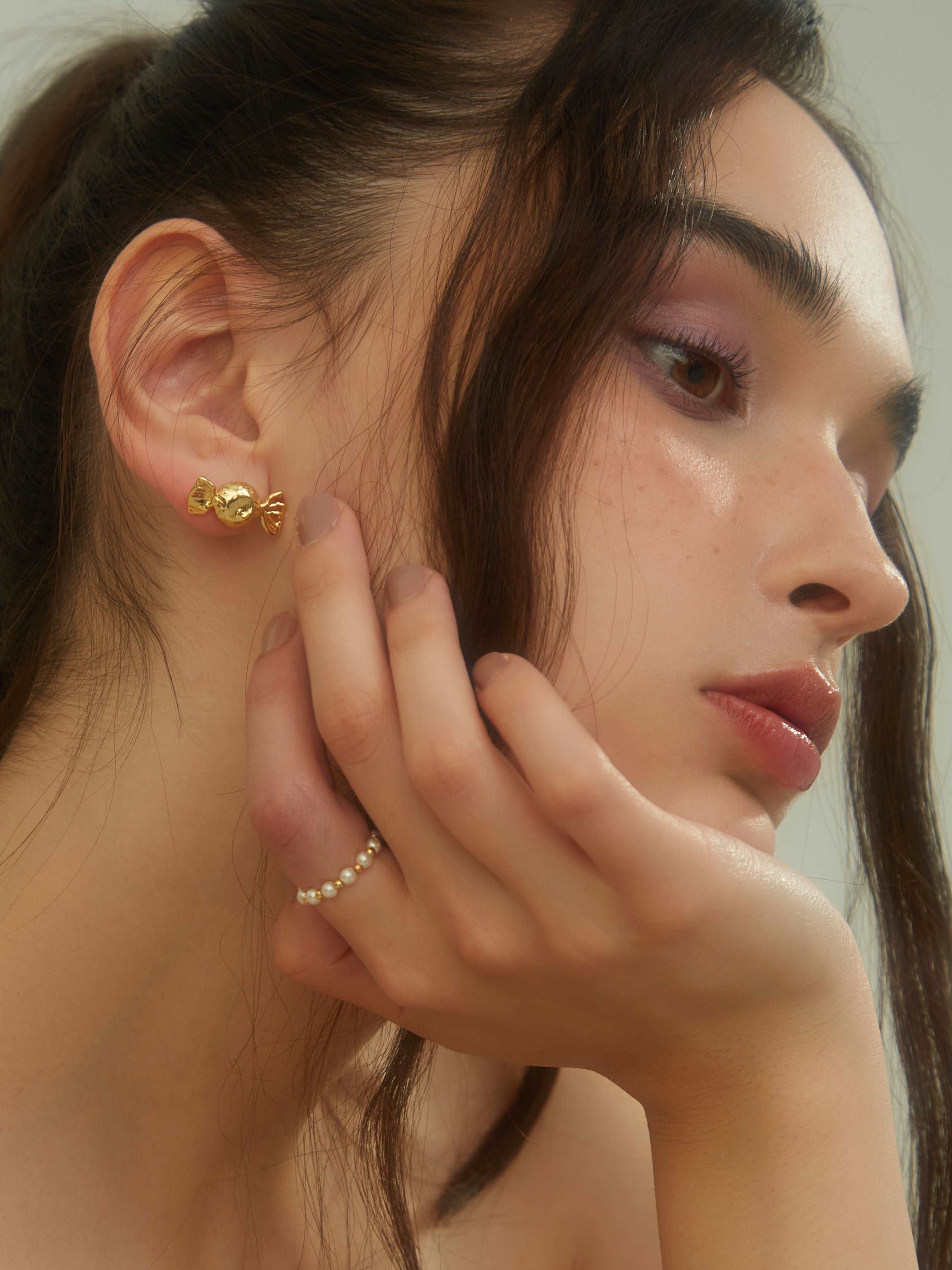 wearing Gold Candy Studs Earrings and pearl beaded ring