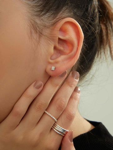 wearing silver Silver Cube Studs Earrings, classic silver ring and pearl beaded ring